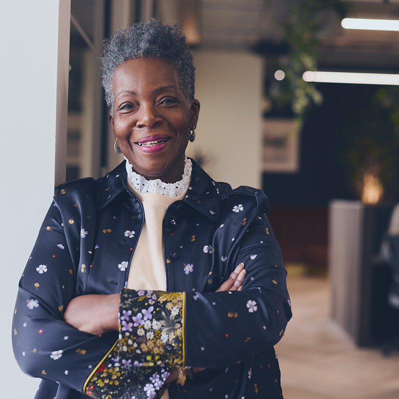 Older female investor standing and smiling