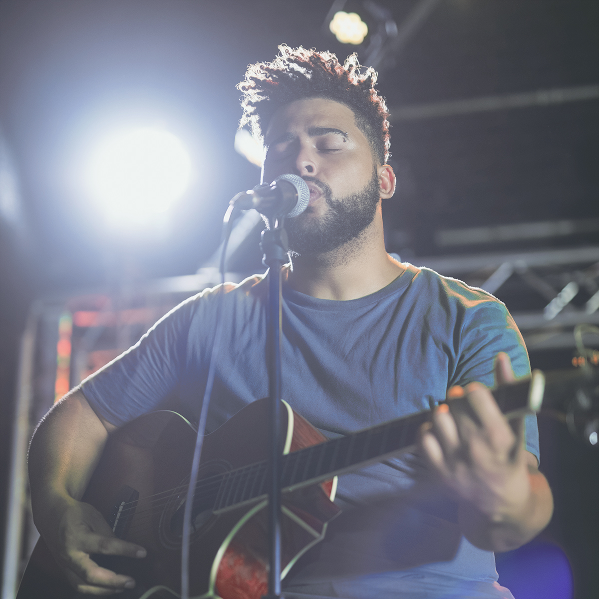 Male musician singing and playing guitar